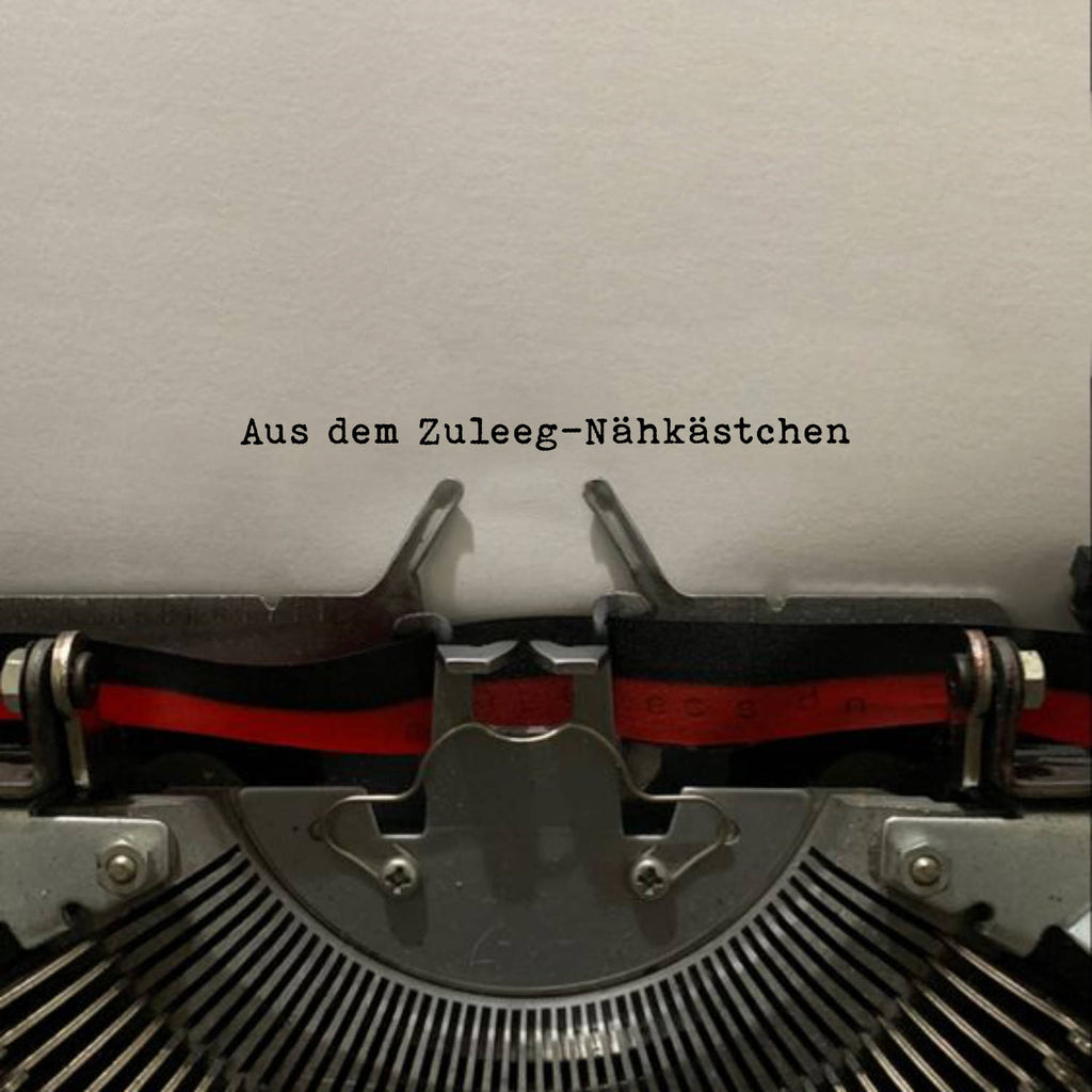 Ein in eine Schreibmaschine eingeklemmtes Papier mit der Aufschrift "Aus dem Zuleeg-Nähkästchen".