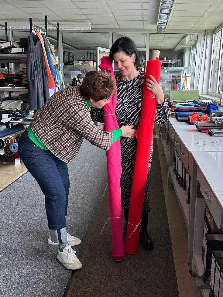 Zwei Damen im Werksverkauf mit zwei Stoffrollen